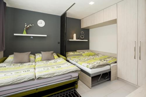 ストジェツにあるApartmány Stožec - Stela Premiumのグレーの壁のベッドルームにツインベッド2台が備わります。