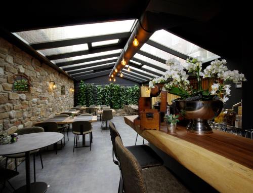 a restaurant with tables and chairs and a counter with flowers at Hotel Inn Naeldwyk-Torenburg in Naaldwijk