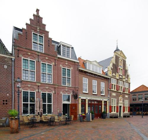 a group of buildings with tables and chairs in a courtyard at Hotel Inn Naeldwyk-Torenburg in Naaldwijk