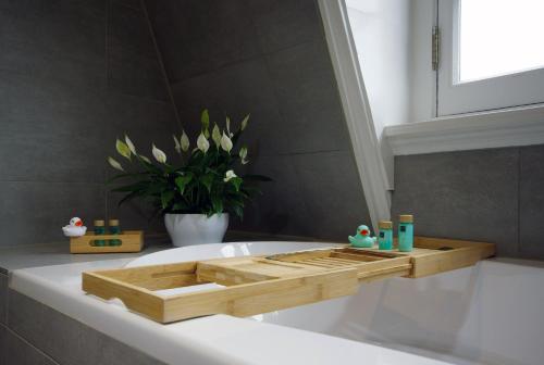 a bathroom with a wooden tray on a bath tub at Hotel Inn Naeldwyk-Torenburg in Naaldwijk
