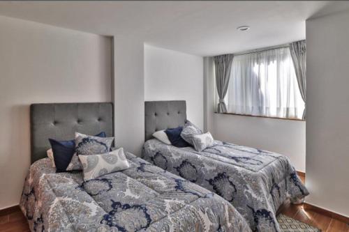 een slaapkamer met 2 bedden en een raam bij Vive la Roma, ubicación ideal in Mexico-Stad