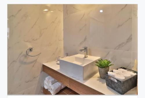 ein Badezimmer mit einem weißen Waschbecken und einer Dusche in der Unterkunft Vive la Roma, ubicación ideal in Mexiko-Stadt