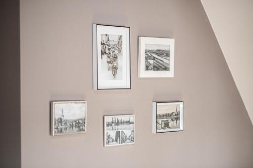 four framed pictures on a white wall at maindrei - schlafen am fluss in Margetshöchheim