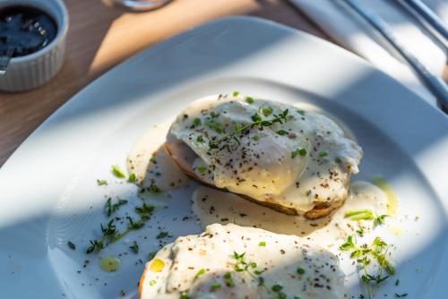 two fried eggs on a white plate on a table at Katouna Suites Luxury Boutique Hotel Adults Only in Lygia