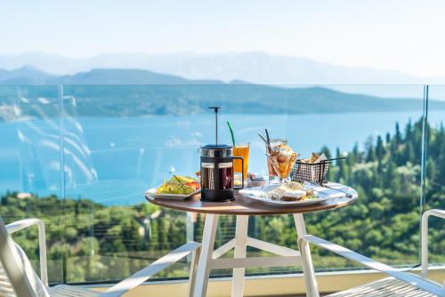 ein Tisch mit Essen und Getränken auf einem Balkon in der Unterkunft Katouna Suites Luxury Boutique Hotel Adults Only in Lygia