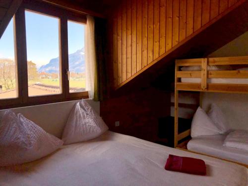 a bedroom with a bed and two windows at central beauty scenery apartment in Interlaken