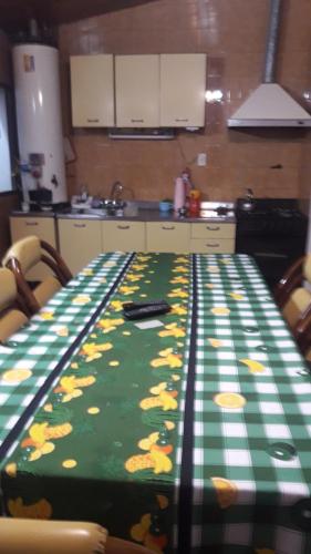a kitchen with a table with a green and yellow table cloth at Alojamiento Milu in Godoy Cruz