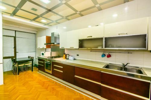 een keuken met witte kasten en een houten vloer bij VİP Apartment number one in Baku