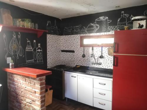 Achalay في بونتا ديل ديابلو: مطبخ بجدران سوداء وثلاجة حمراء