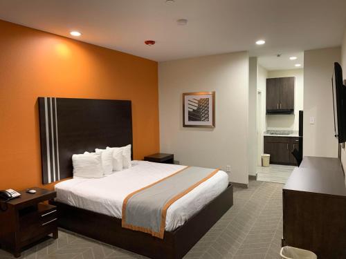 a hotel room with a bed and a kitchen at Scottish Inn & Suites - IAH Airport in Humble