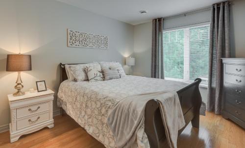 - une chambre avec un grand lit et une fenêtre dans l'établissement Condo Entre Ville et Nature 2, à Magog