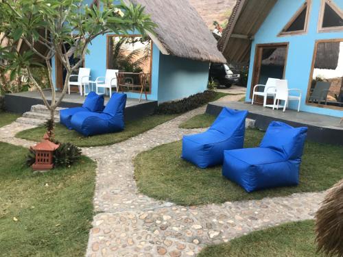 un groupe de chaises bleues devant une maison dans l'établissement Blue Monkey Retreat Areguling Lombok, à Kuta Lombok