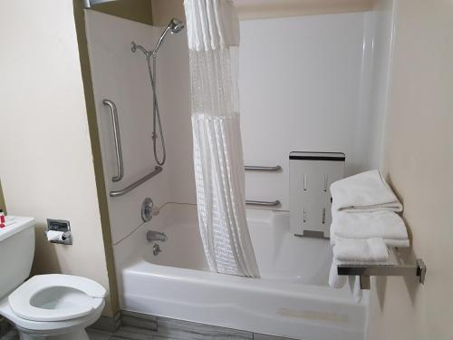 a white bathroom with a shower and a toilet at Super 8 by Wyndham Shelton in Shelton