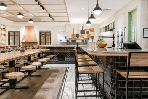 a restaurant with wooden tables and chairs and a bar at Best Western Plus Baker Street Inn in Nelson
