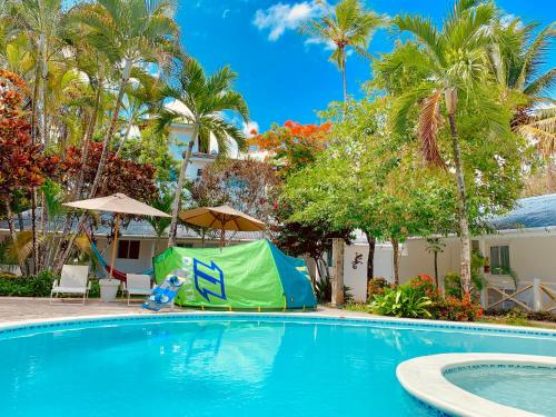 a swimming pool with a tent next to a house at Beach Hotel Casa Nina in Las Terrenas