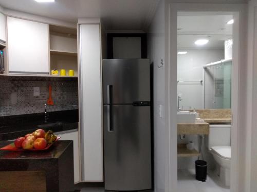 einen Kühlschrank aus Edelstahl in einer Küche mit einer Schale Obst in der Unterkunft Mamelucos Chalé 11 Praia do Flamengo in Salvador