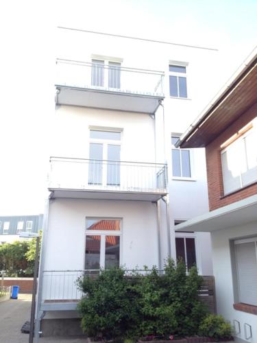 - un bâtiment blanc avec un balcon sur le côté dans l'établissement Apartment Eisberg 2 mit Balkon, à Norderney