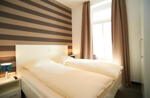 - une chambre dotée d'un lit avec un mur rayé dans l'établissement Apartment Eisberg 2 mit Balkon, à Norderney