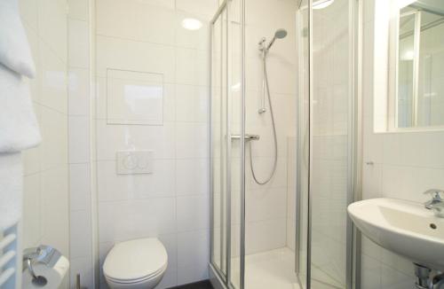 La salle de bains est pourvue d'une douche, de toilettes et d'un lavabo. dans l'établissement Apartment Eisberg 2 mit Balkon, à Norderney