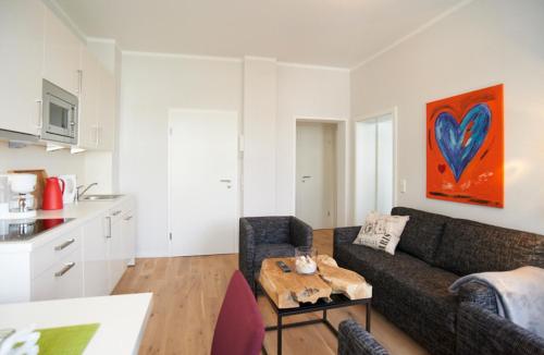 ein Wohnzimmer mit einem Sofa und einem Tisch in der Unterkunft Apartment Eisberg 3 mit schöner Balkonterrasse in Norderney