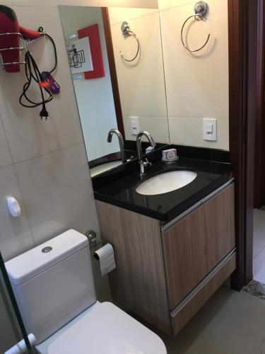a bathroom with a sink and a toilet and a mirror at recanto palmeira imperial Holambra SP in Holambra