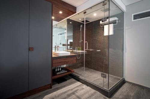 a bathroom with a glass shower and a sink at PentStudio West Lake Hanoi in Hanoi