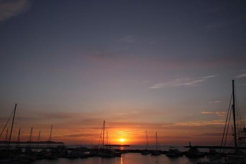 una puesta de sol sobre un puerto con barcos en el agua en Atelier & Hostel Nagaisa-Ura en Atami