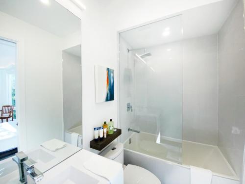 a white bathroom with a sink and a shower at Elegant Downtown Home in Toronto