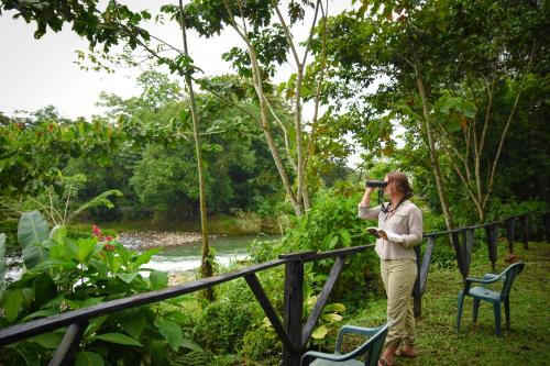 a woman taking a picture of a river with a camera at Chilamate Rainforest Eco Retreat in Puerto Viejo
