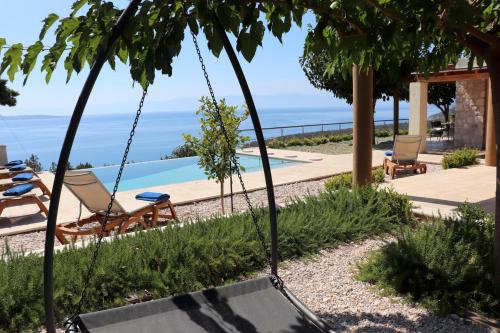 a swing in front of a house with a swimming pool at IRIDA in Koilás