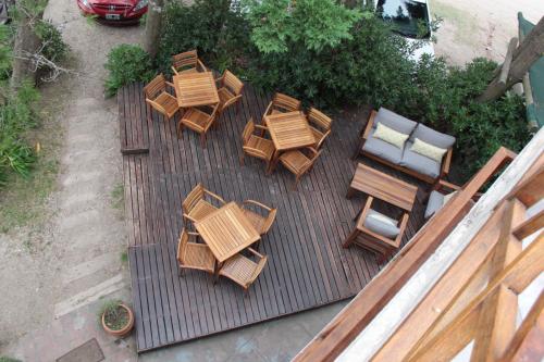 una hilera de sillas de madera sentadas en lo alto de un patio del Hotel Romina de Villa Gesell