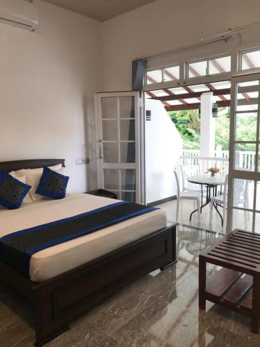 a bedroom with a bed and a patio with a table at Dumi's Shelter Home Stay in Colombo