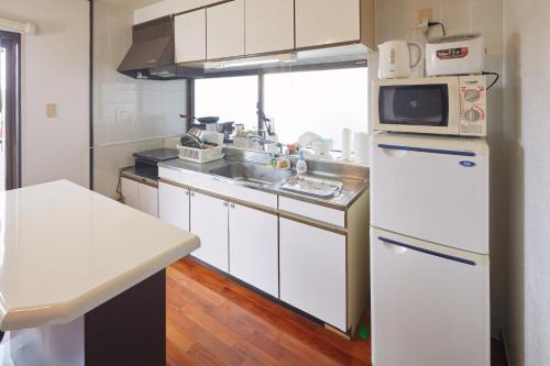 a kitchen with a white refrigerator and a microwave at Wind Henza in Henza