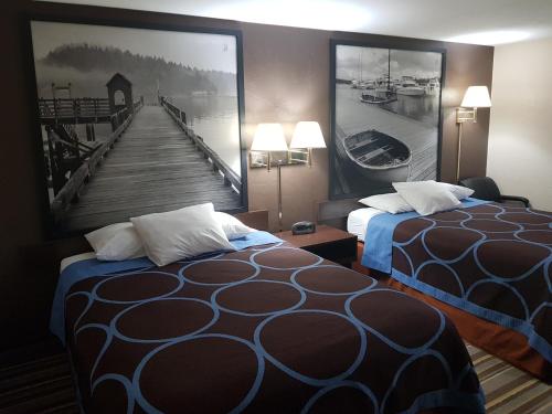 a hotel room with two beds and a picture of a pier at Super 8 by Wyndham Shelton in Shelton