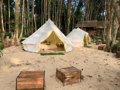 un groupe de tentes dans le sable avec des arbres dans l'établissement O Little Tent de Koh Chang, à Ranong