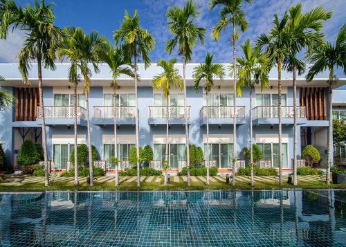 a hotel with palm trees and a swimming pool at Blu Marine Hua Hin Resort and Villas - SHA Plus in Hua Hin
