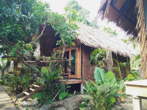a small house with a straw roof at The Tropical Koh Mook in Koh Mook