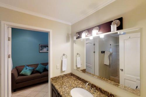 a bathroom with a sink and a mirror and a couch at Sunrise 22 in Tamarindo
