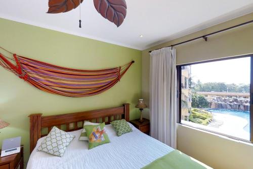 a bedroom with a bed and a large window at Sunrise 22 in Tamarindo