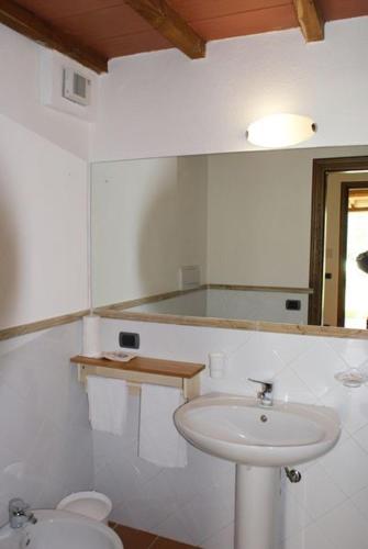 a white bathroom with a sink and a toilet at Agriturismo Le Spighe in San Donato