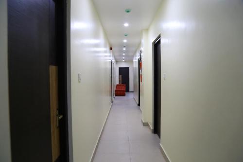 a hallway with white walls and a long hallway with doors at Hotel Landmark in Port Blair