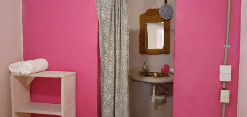 a pink bathroom with a sink and a mirror at Lola Atlachinolli in Sayulita