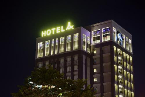 un panneau d'hôtel au-dessus d'un bâtiment la nuit dans l'établissement Hotel A, à Tainan