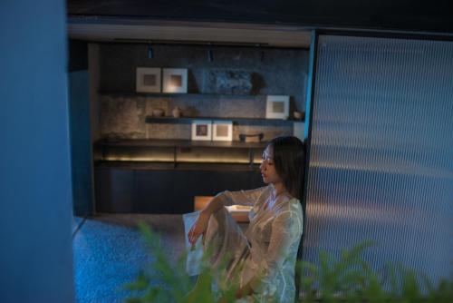 a woman sitting in front of a building at Yakamoz Erhai Hotel in Dali