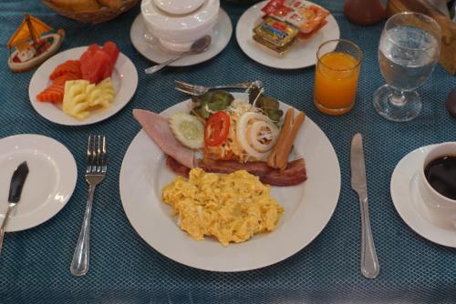 ein Tisch mit Tellern voller Frühstücksspeisen darauf in der Unterkunft Kao Tao Villa Beach Resort-Hua Hin in Khao Tao