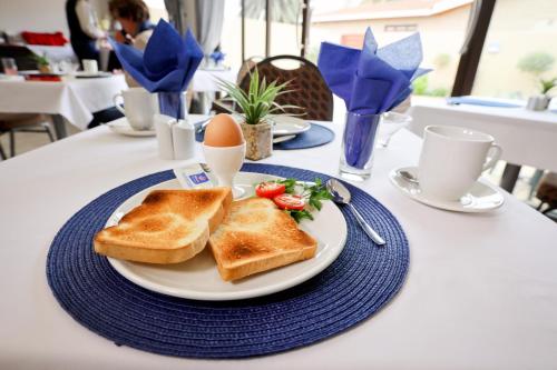 un plato blanco con tostadas y tomates en una mesa en Desert Jackal Guesthouse, en Swakopmund