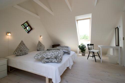 1 dormitorio con cama con almohadas y ventana en Munkebjerg Bed & Breakfast, en Børkop