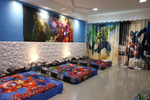 three beds in a room with superheroes on the wall at Vince's ICity Soho Homestay water park red carpet shah alam light city central in Shah Alam