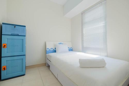 Un dormitorio con una cama blanca y una ventana. en Minimalist 2BR Apartment The Springlake Summarecon By Travelio, en Bekasi