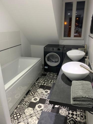 a bathroom with a tub and a sink and a toilet at Le Petit Chez Soi in Calais